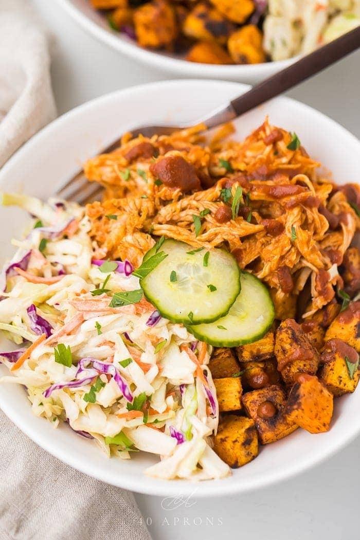 A person assembling the BBQ Chicken and Coleslaw Bowls, highlighting the ease of preparation.