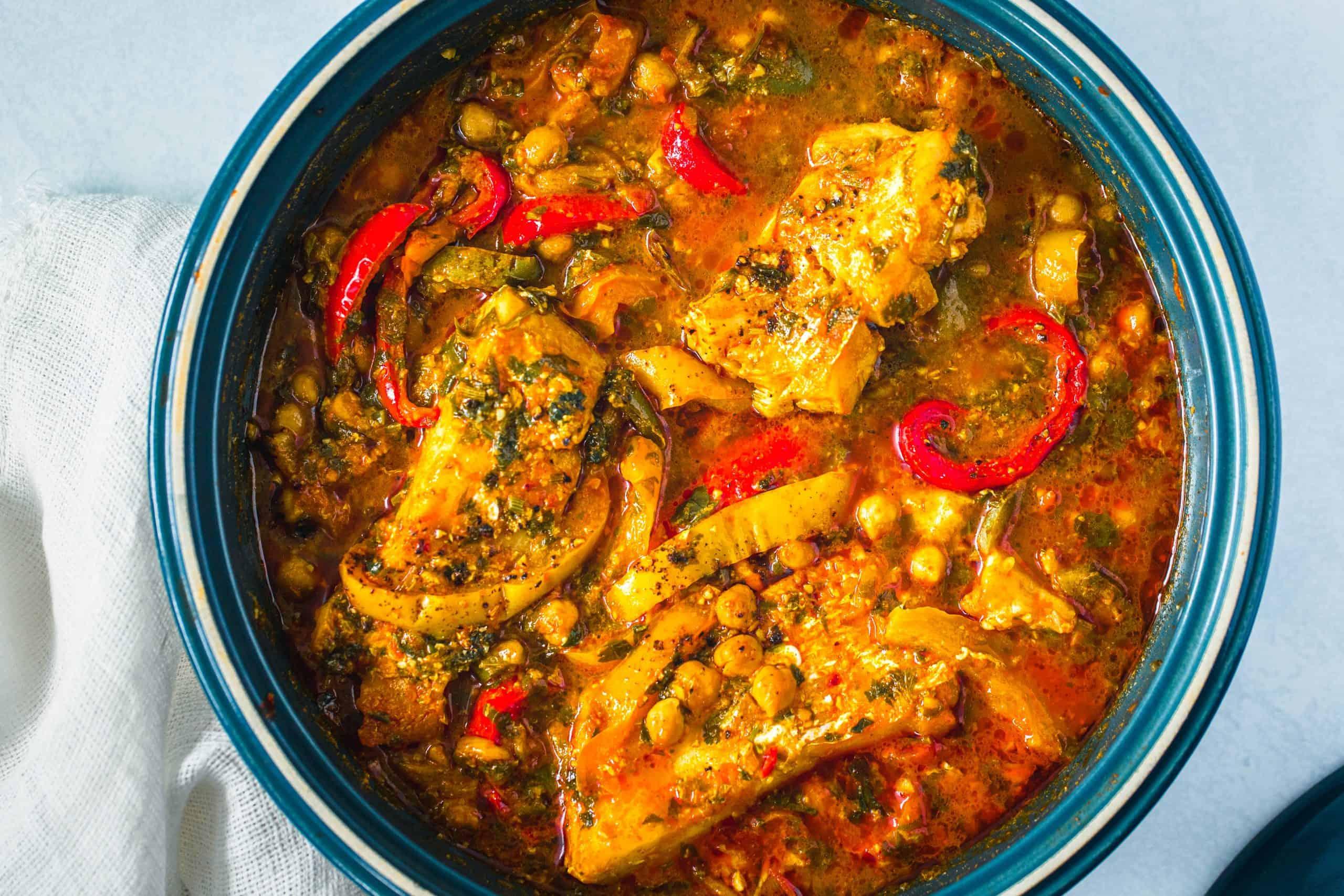 Close up of a finished fish tagine, showing the vibrant colors and texture of the ingredients.