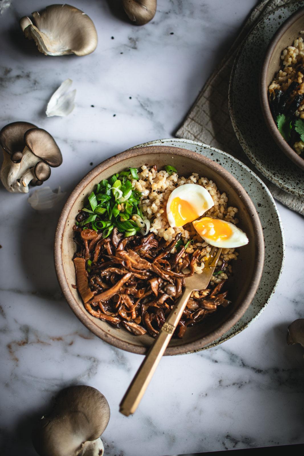 A person happily eating a bowl of Mushroom and Swiss Rice Bowl.