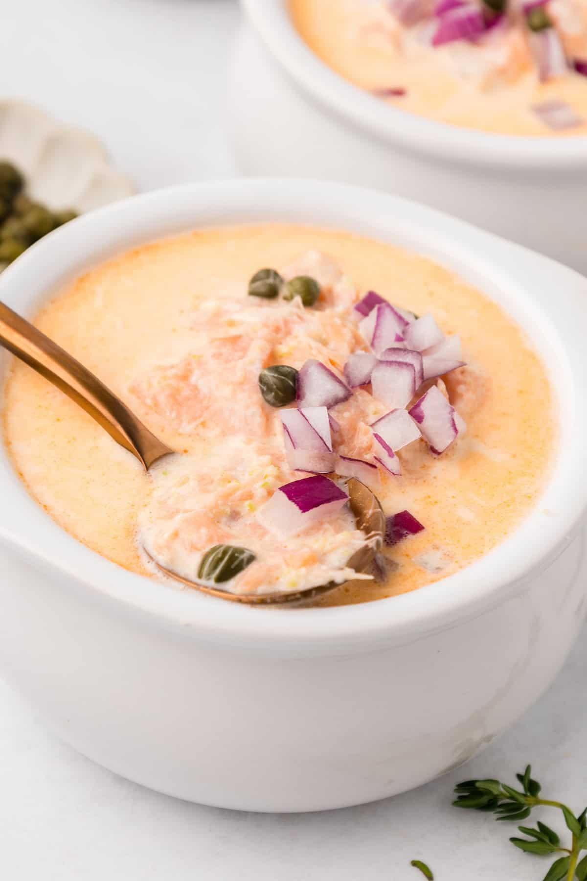 Close-up shot of a bowl of lobster chowder with smoked salmon