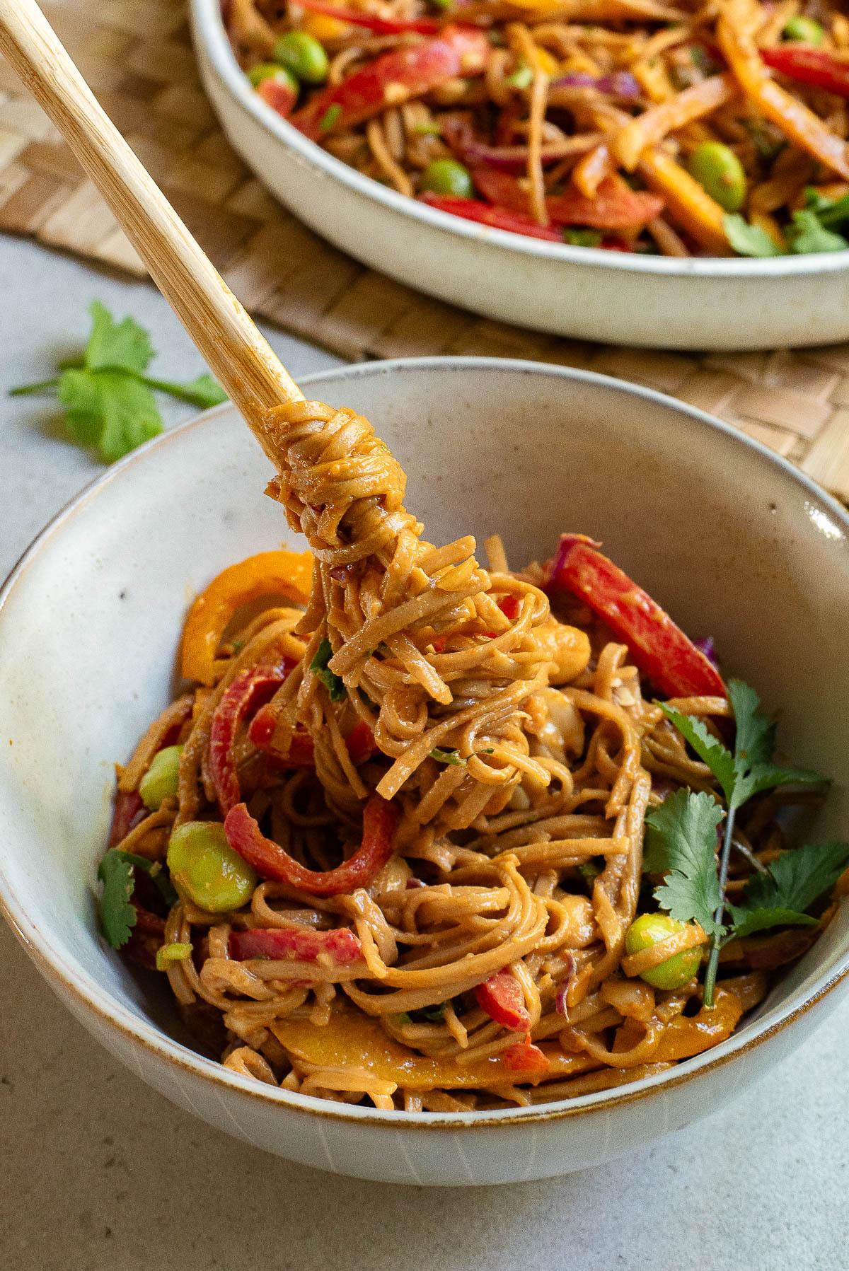 close-up of ingredients being added to spicy peanut noodle salad