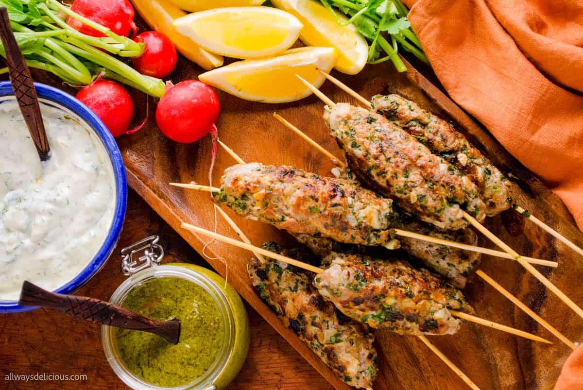 Close-up shot of injera-wrapped kofta kebabs, garnished with fresh herbs