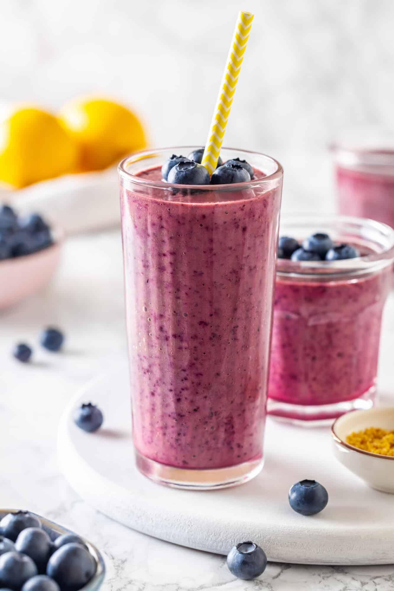 Glass of blueberry coconut cream smoothie garnished with blueberries and coconut flakes