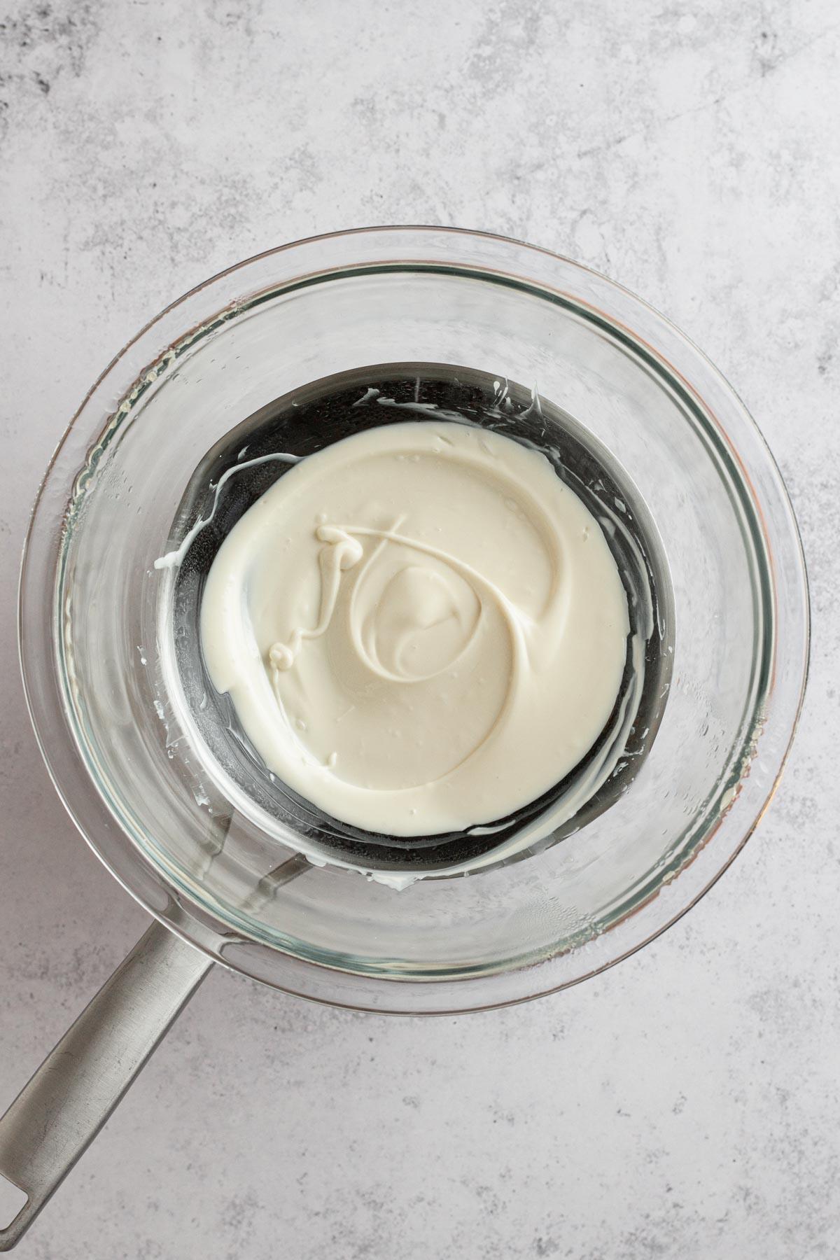 Close-up shot of white chocolate melting smoothly in a double boiler