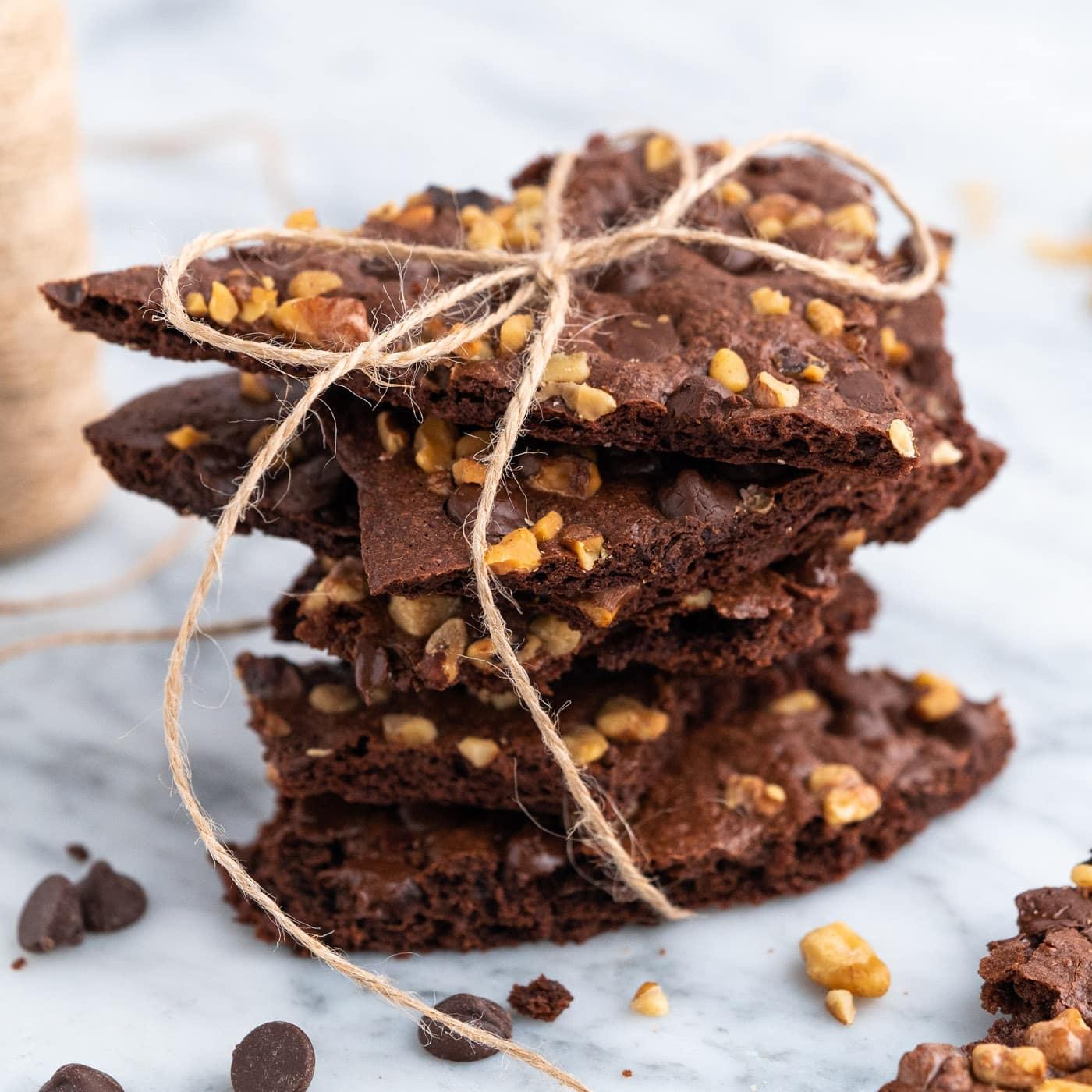 Brownie brittle bites with candied pecans on a baking sheet