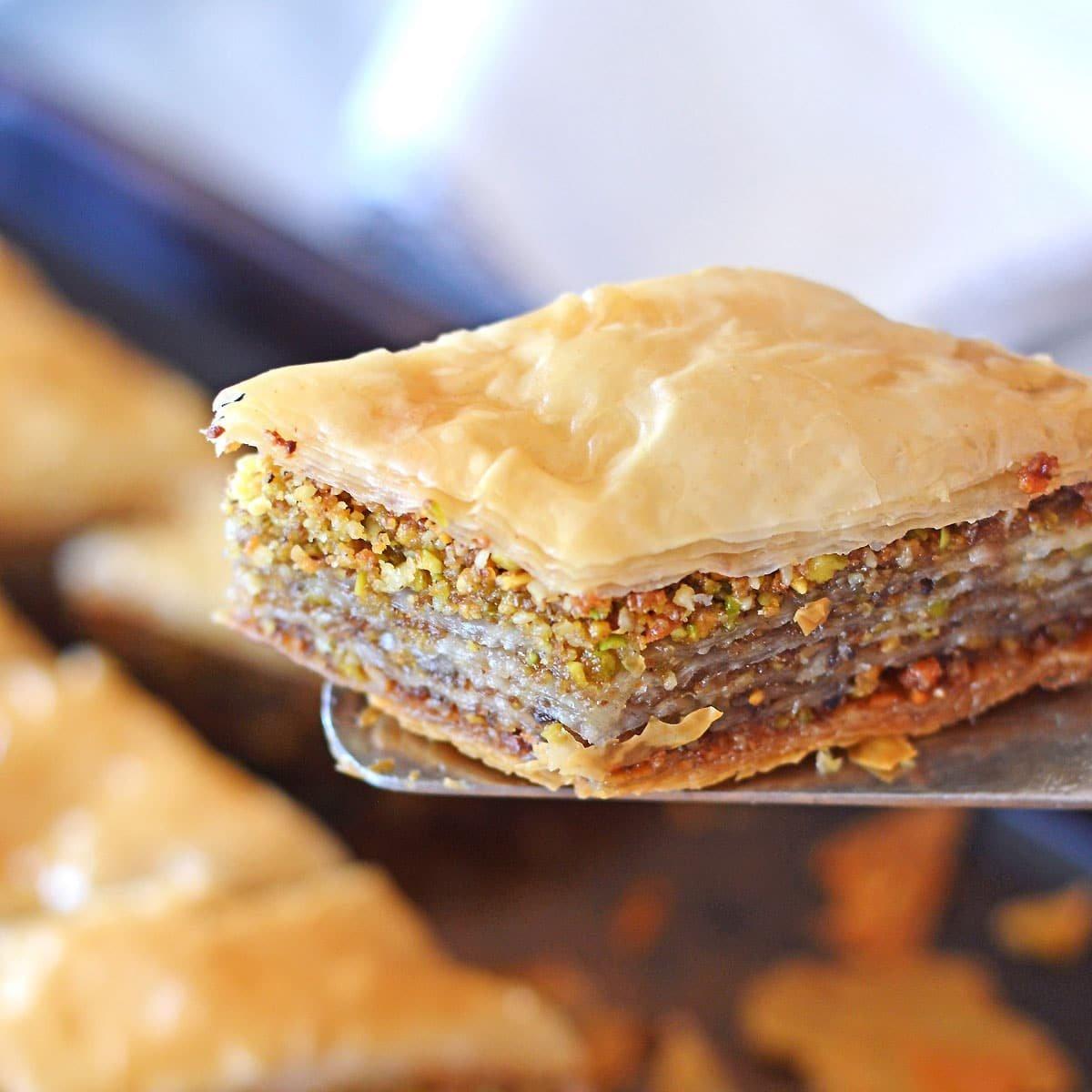 A golden-brown baklava with cream cheese filling, drizzled with honey syrup, cut into diamond shapes