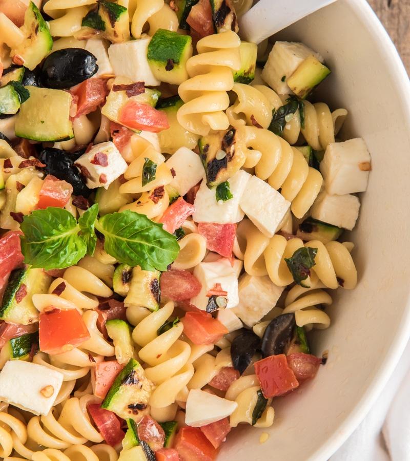 A vibrant Italian pasta salad with prosciutto, fresh mozzarella, and colorful vegetables