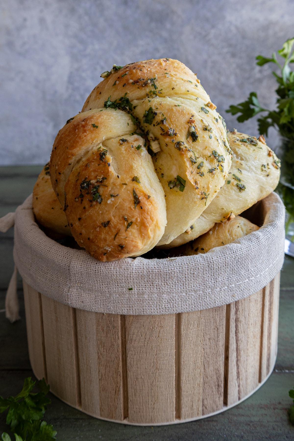 Warm parmesan garlic knots on a rustic wooden board, steam rising, cozy kitchen background