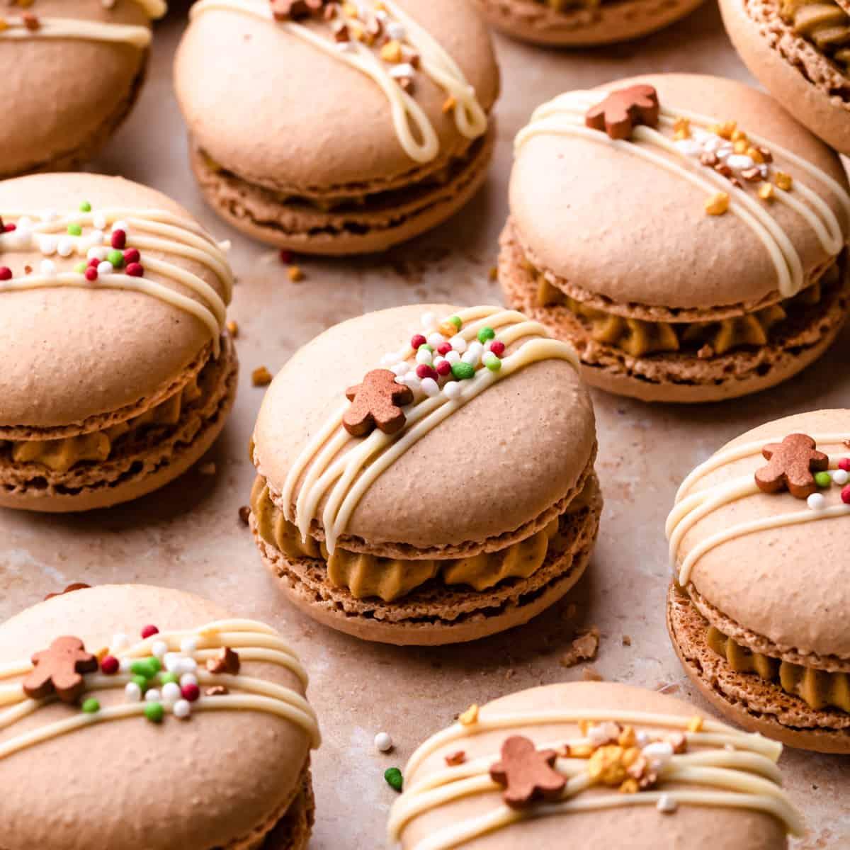 close up of gingerbread macarons with dusted sugar on a wooden platter
