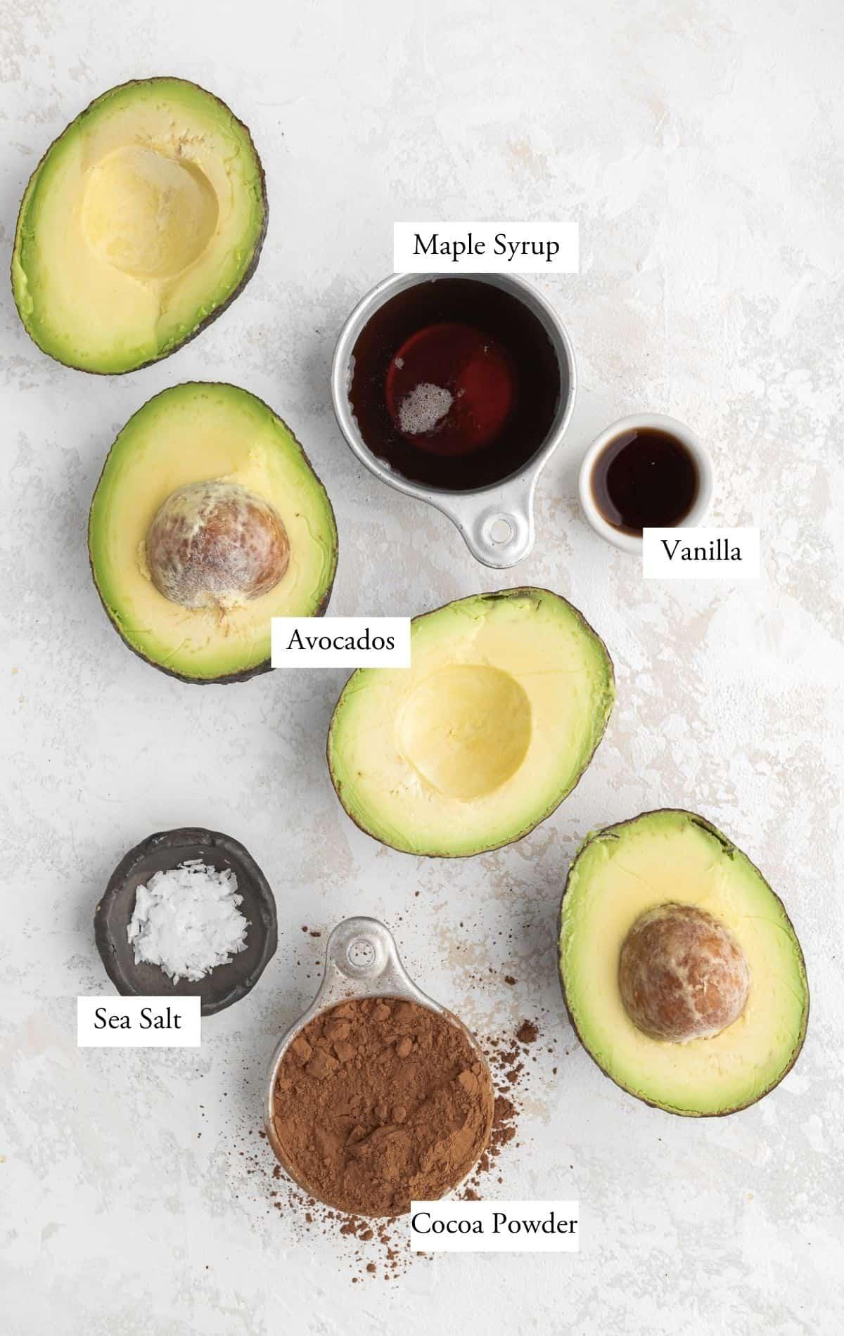 Close up of ingredients: avocado, chocolate, heavy cream, sea salt