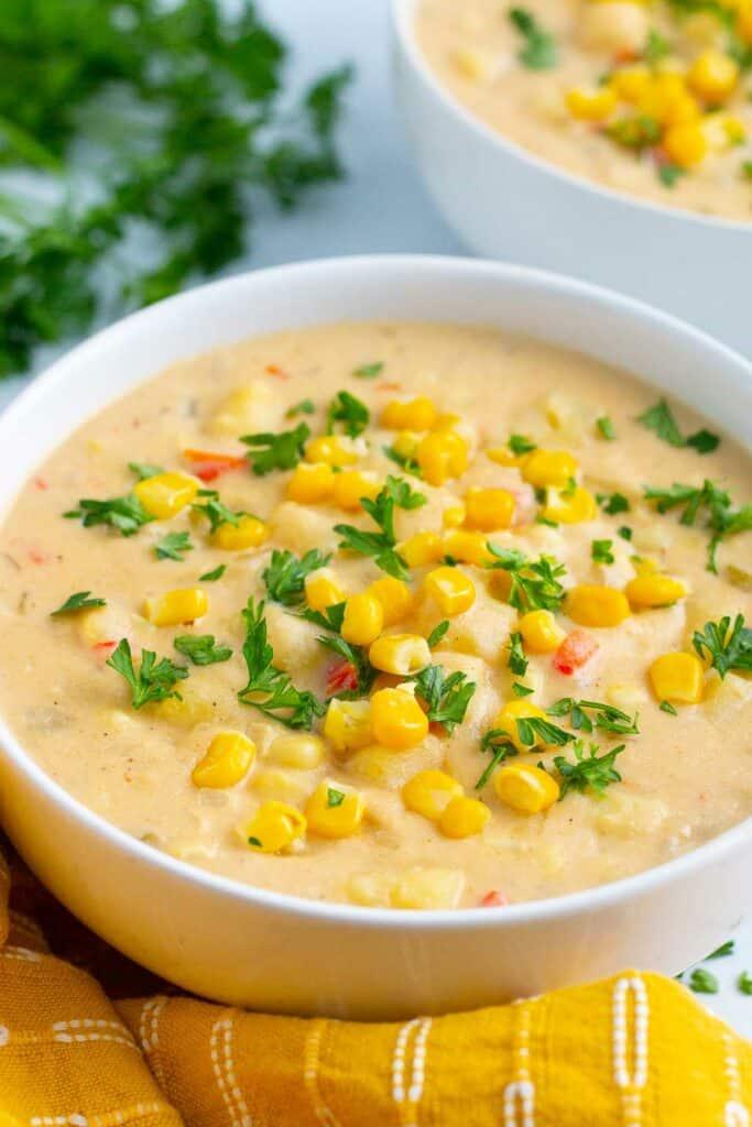 a bowl of vegan corn chowder with fresh parsley garnish
