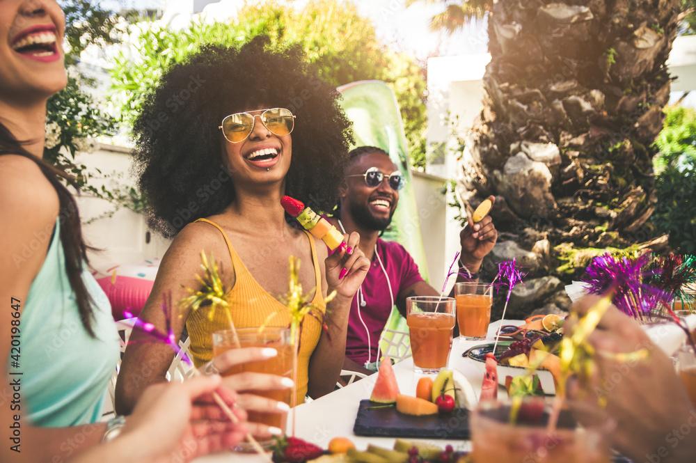 A group of friends laughing and enjoying cocktails at a party