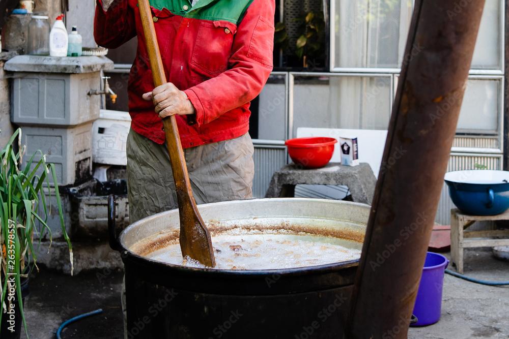 Person adding ingredients to a large pot