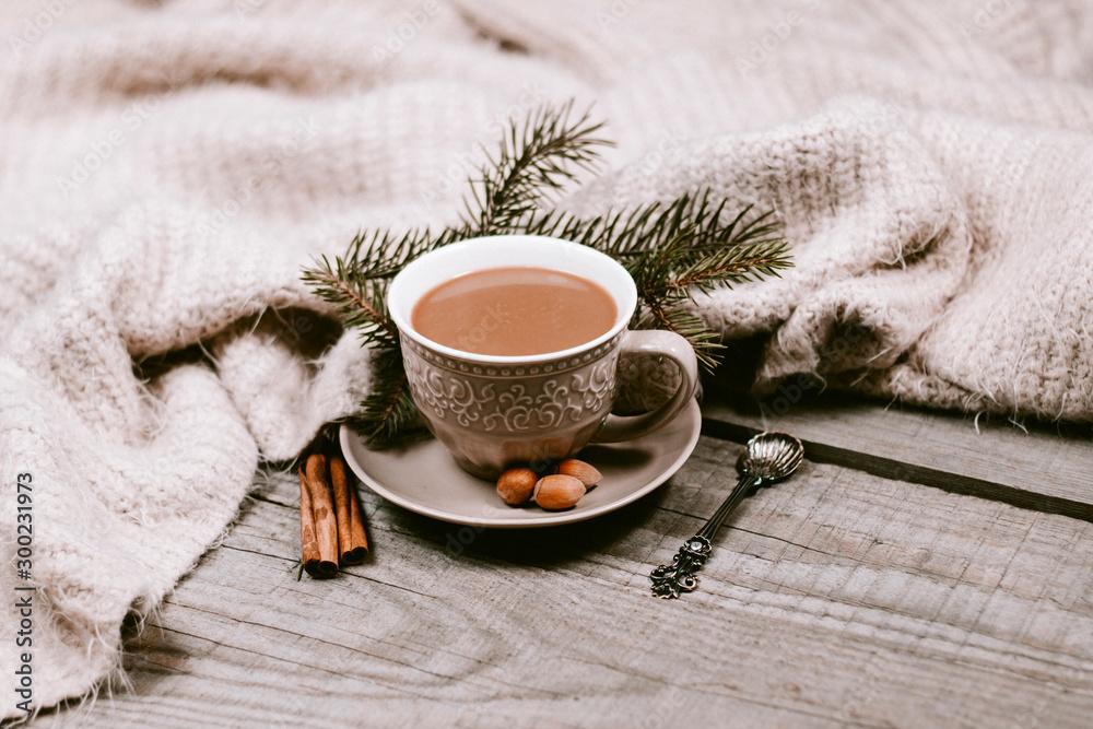 A rustic wooden table with a plate of macadamia maple cookies, a cup of coffee, and a cozy blanket.