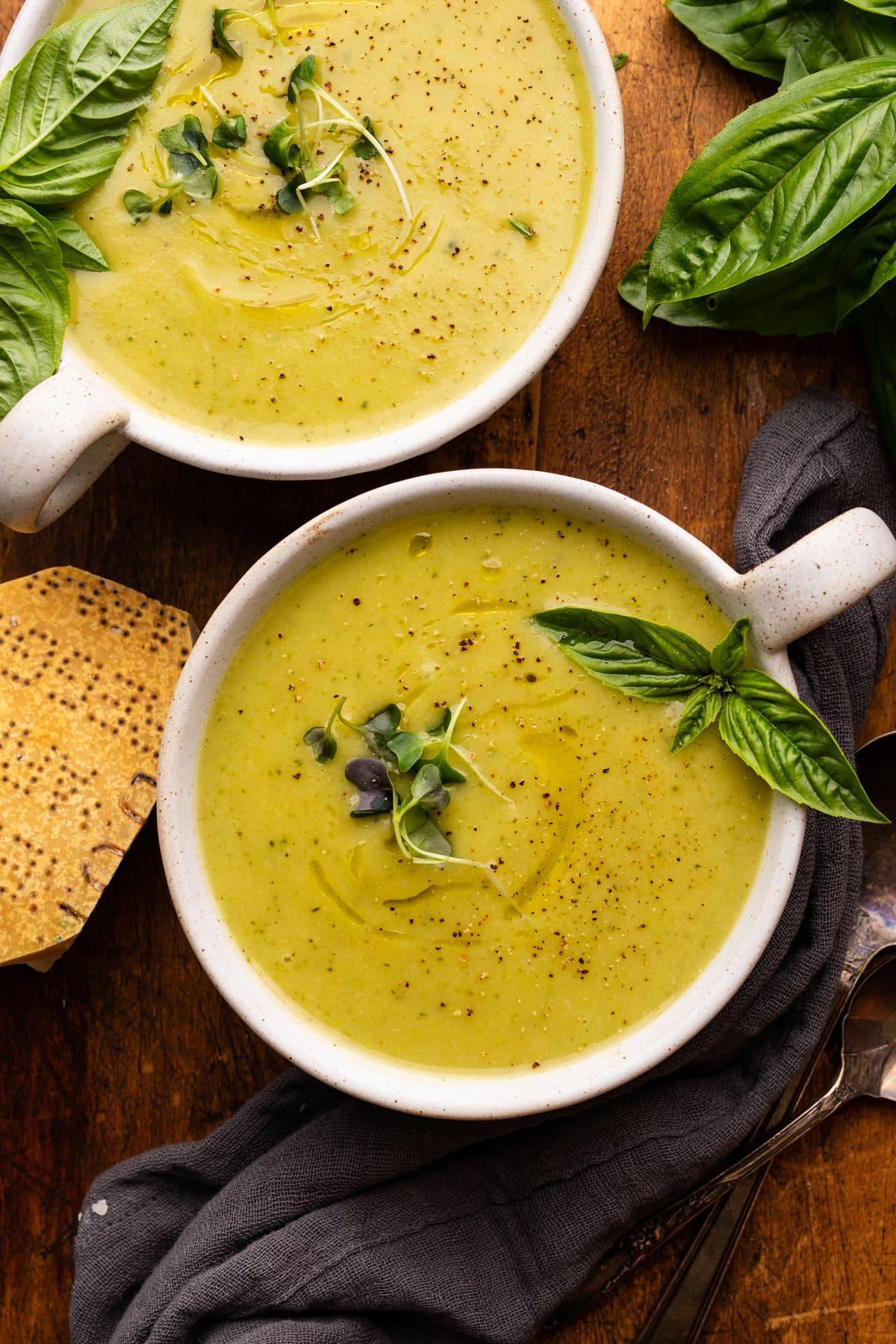 Close up shot of a bowl of creamy garlic parmesan zucchini soup with steam rising
