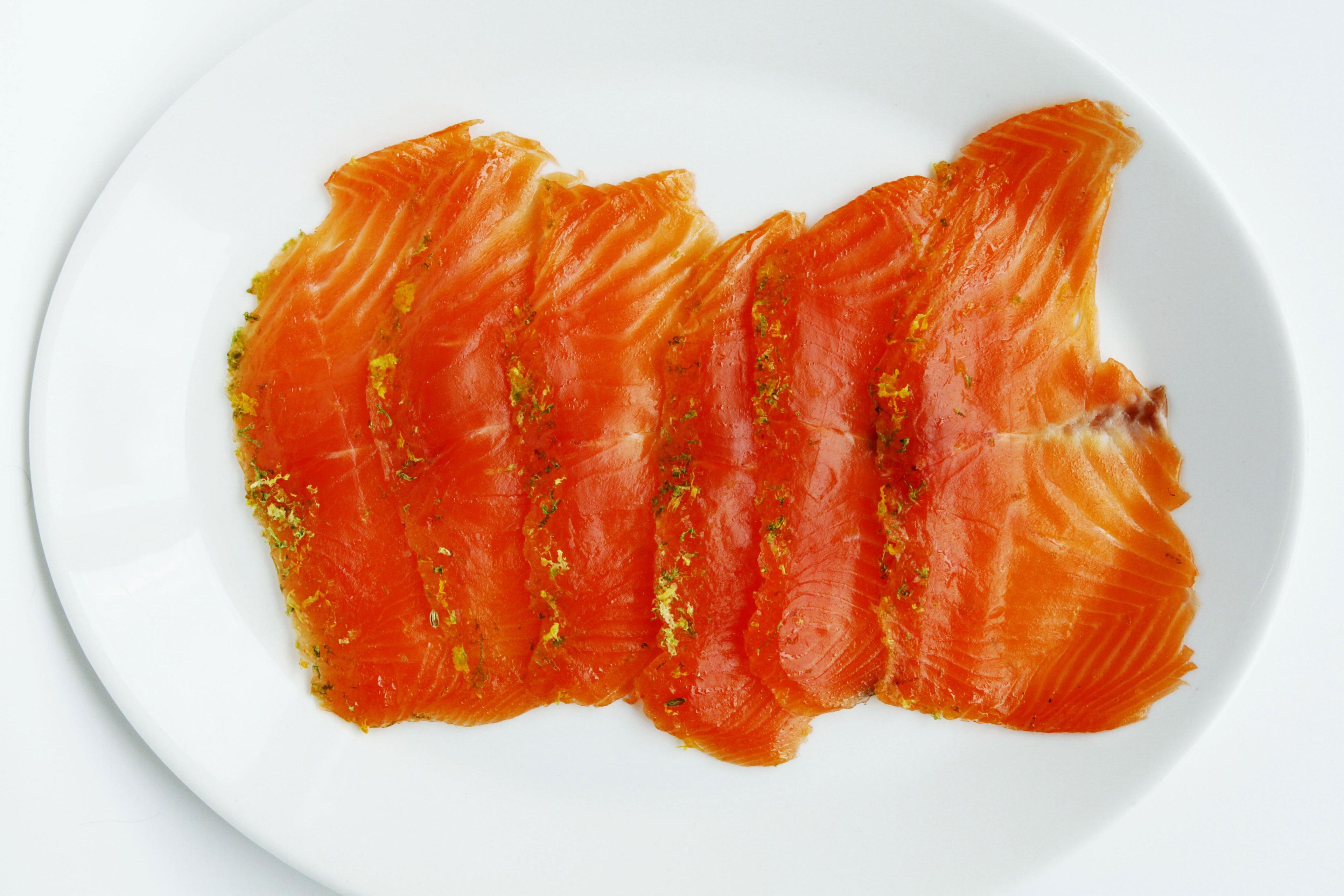 Close-up of the salmon fillet covered in the citrus and champagne mixture, ready for curing