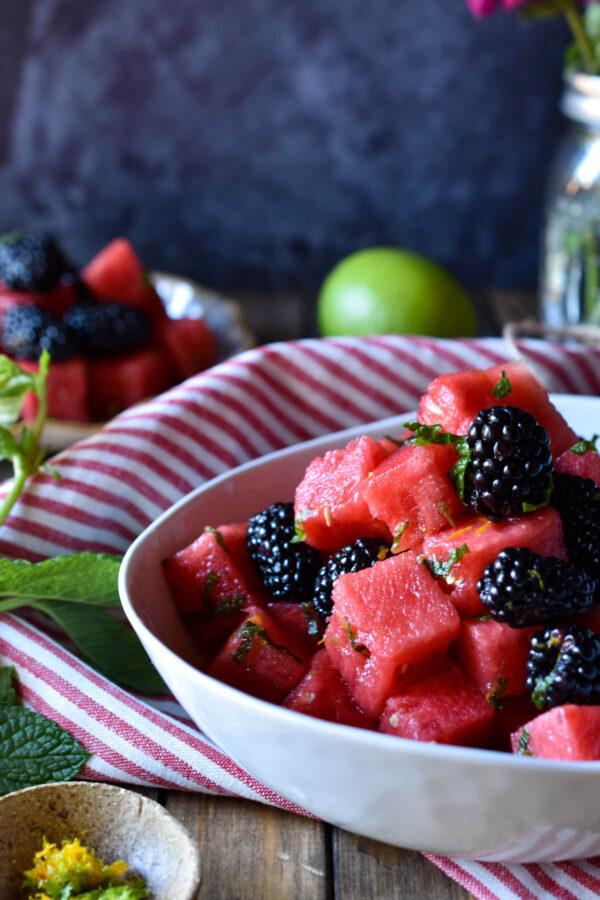 A person enjoying a serving of the Watermelon & Blackberry Salad outdoors