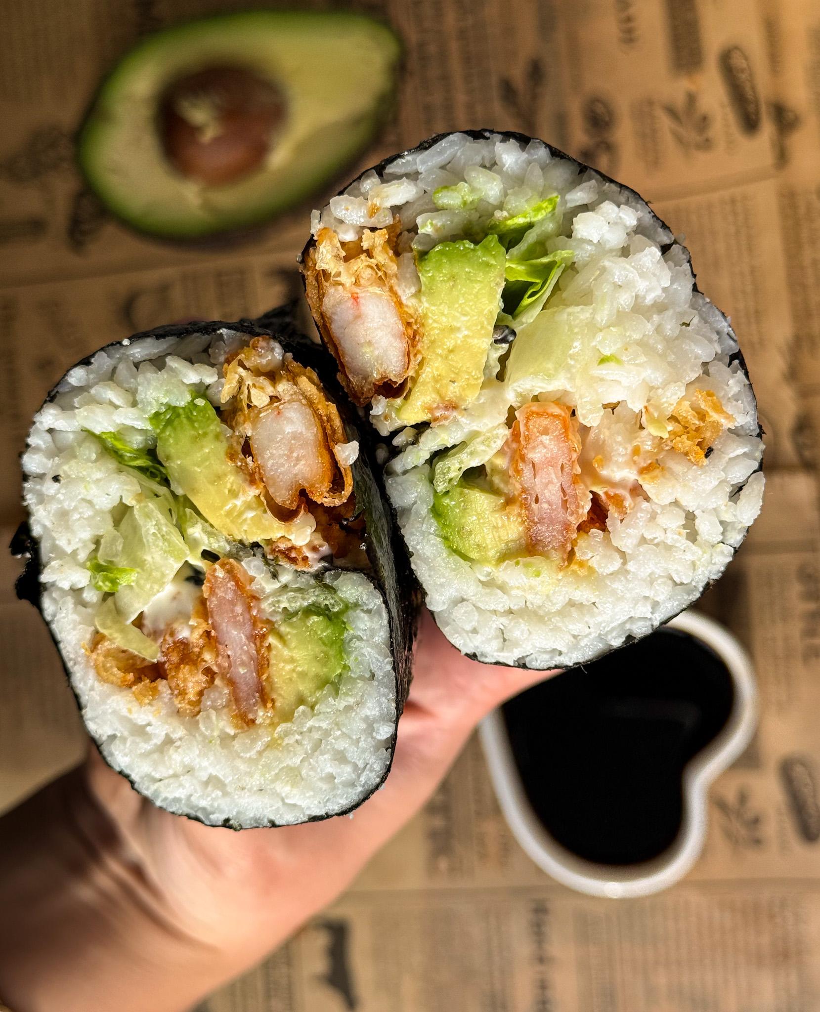 A colorful assortment of sushi burrito fillings, such as shrimp, avocado, and vegetables.