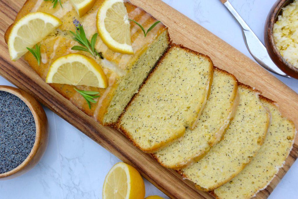 Close-up shot of a slice of lemon poppy seed cake with glaze dripping down the sides
