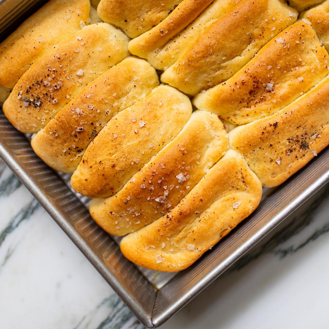 Ingredients for sage and brown butter bagels, including flour, butter, yeast, and fresh sage