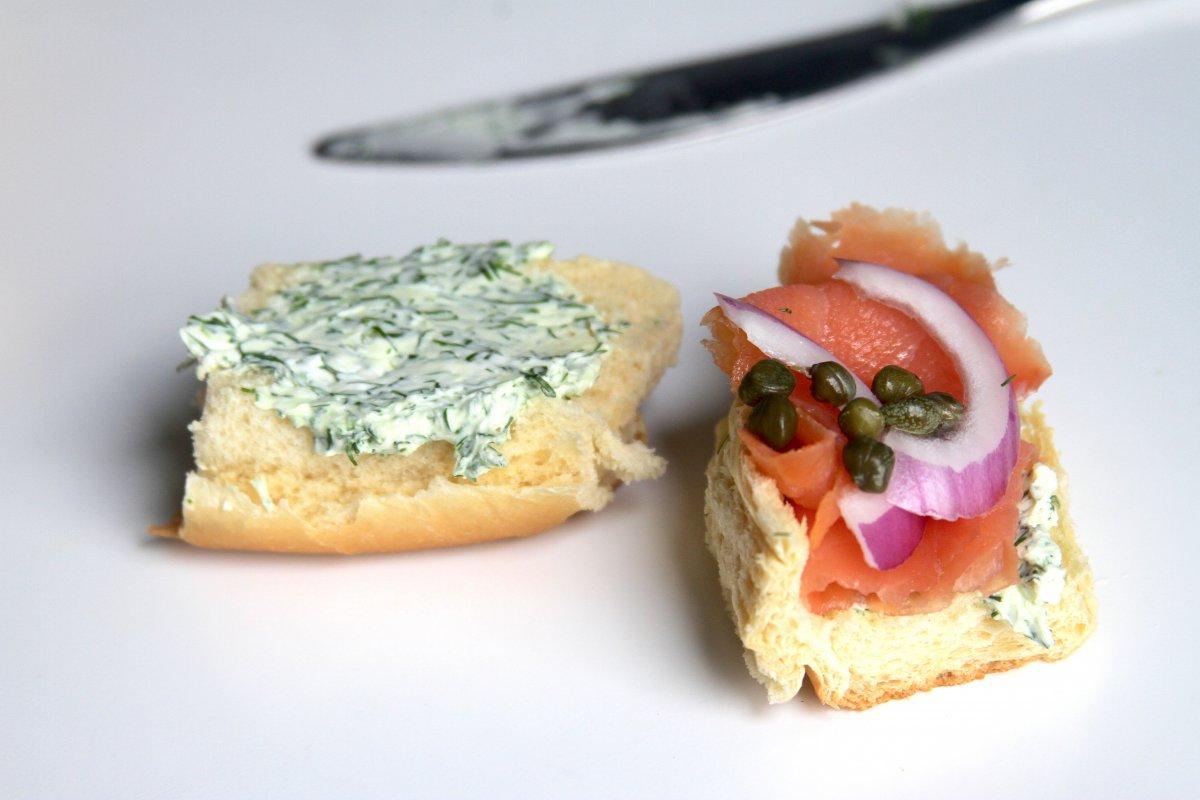 Close-up shot of delicious salmon sliders with dill cream cheese on mini buns, garnished with fresh dill sprigs.