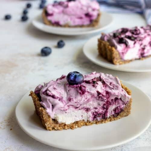 A whole boysenberry cream cheese tart on a plate
