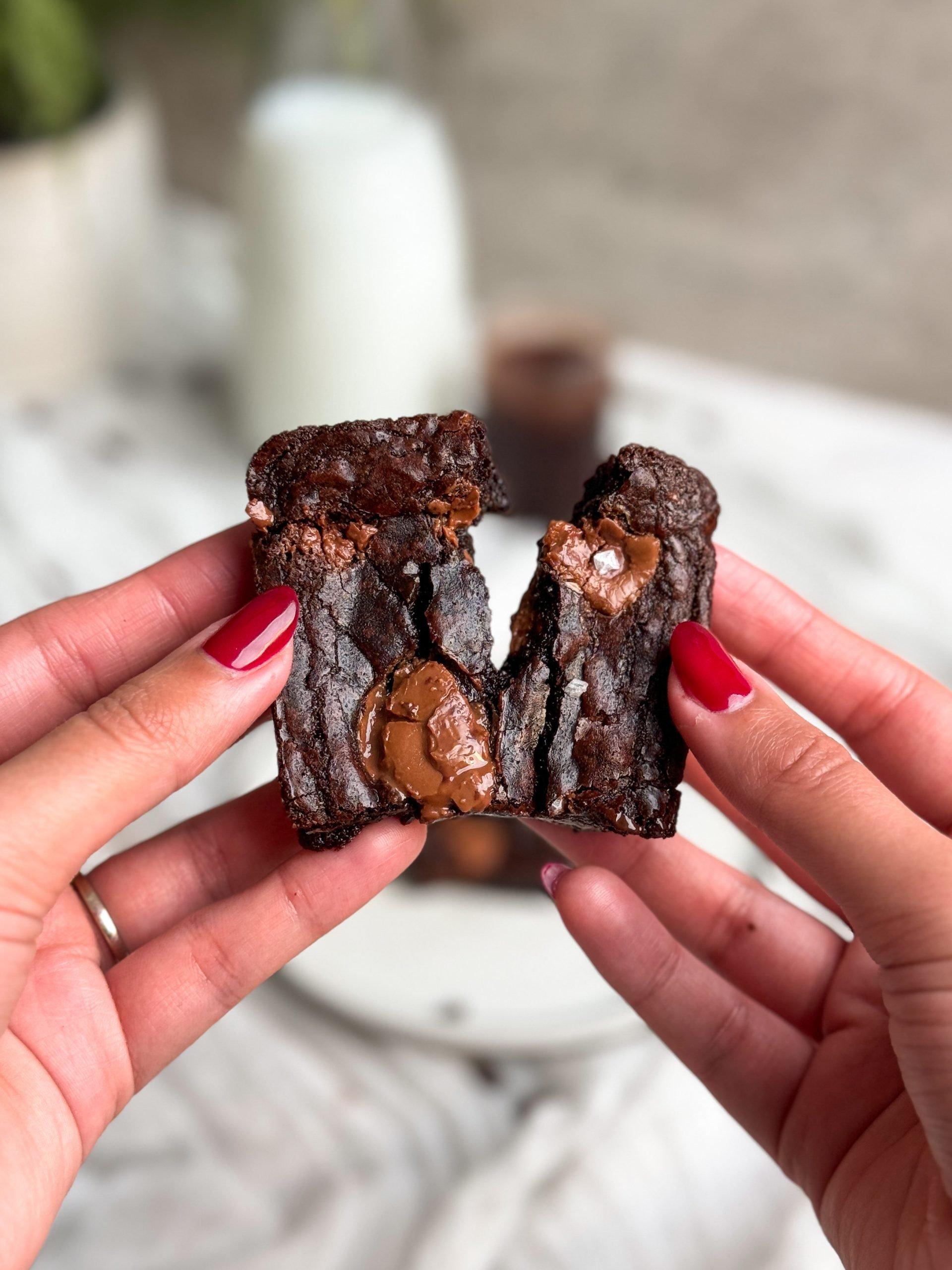 A person holding a piece of bread pudding brownie