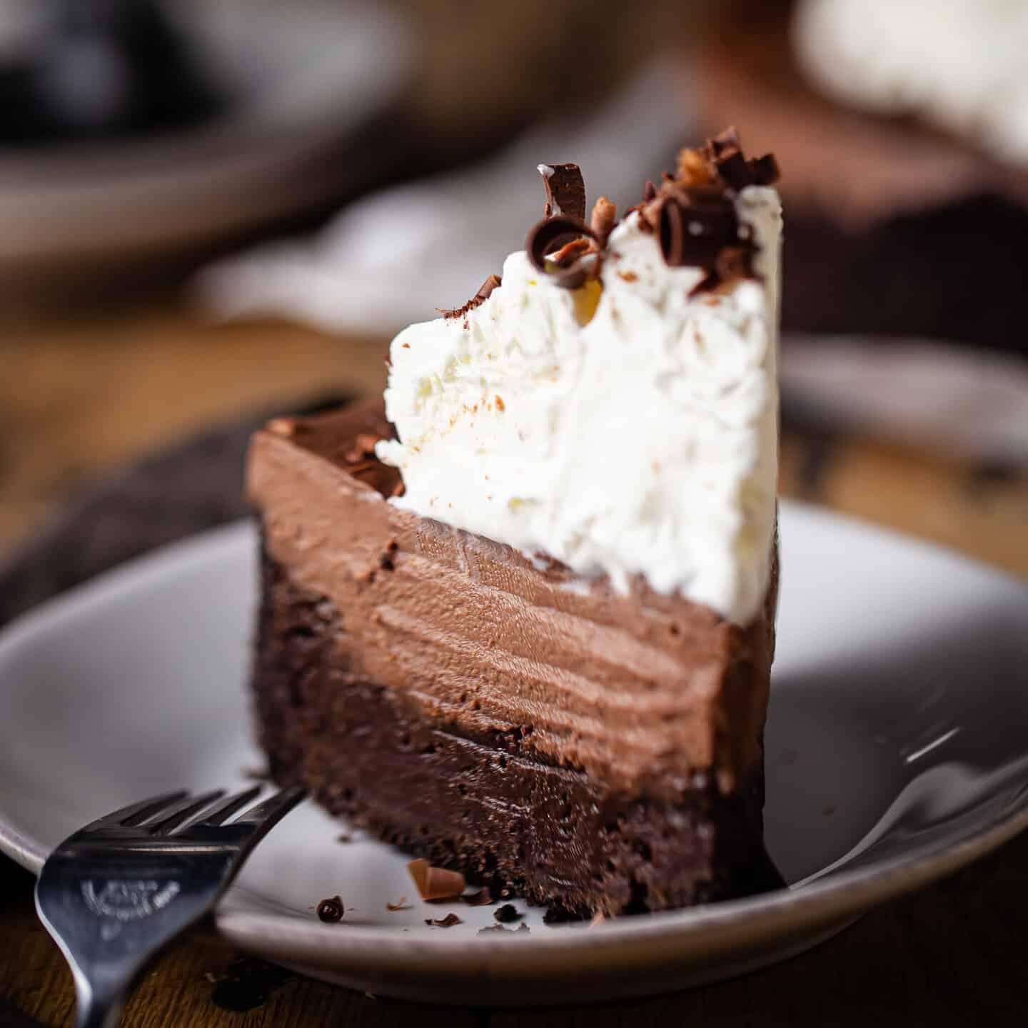 A piece of Mississippi Mud Cake cut and served, with a dollop of whipped cream on top