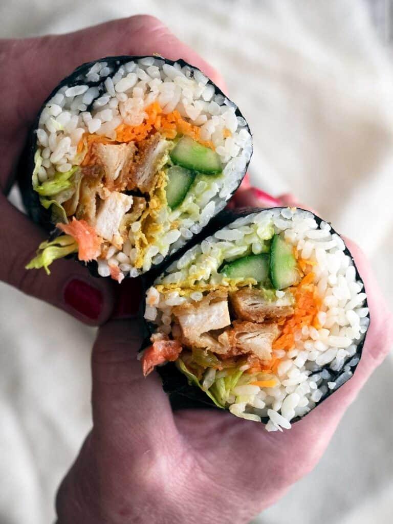 A person expertly rolling a Buffalo Chicken Sushi Burrito.