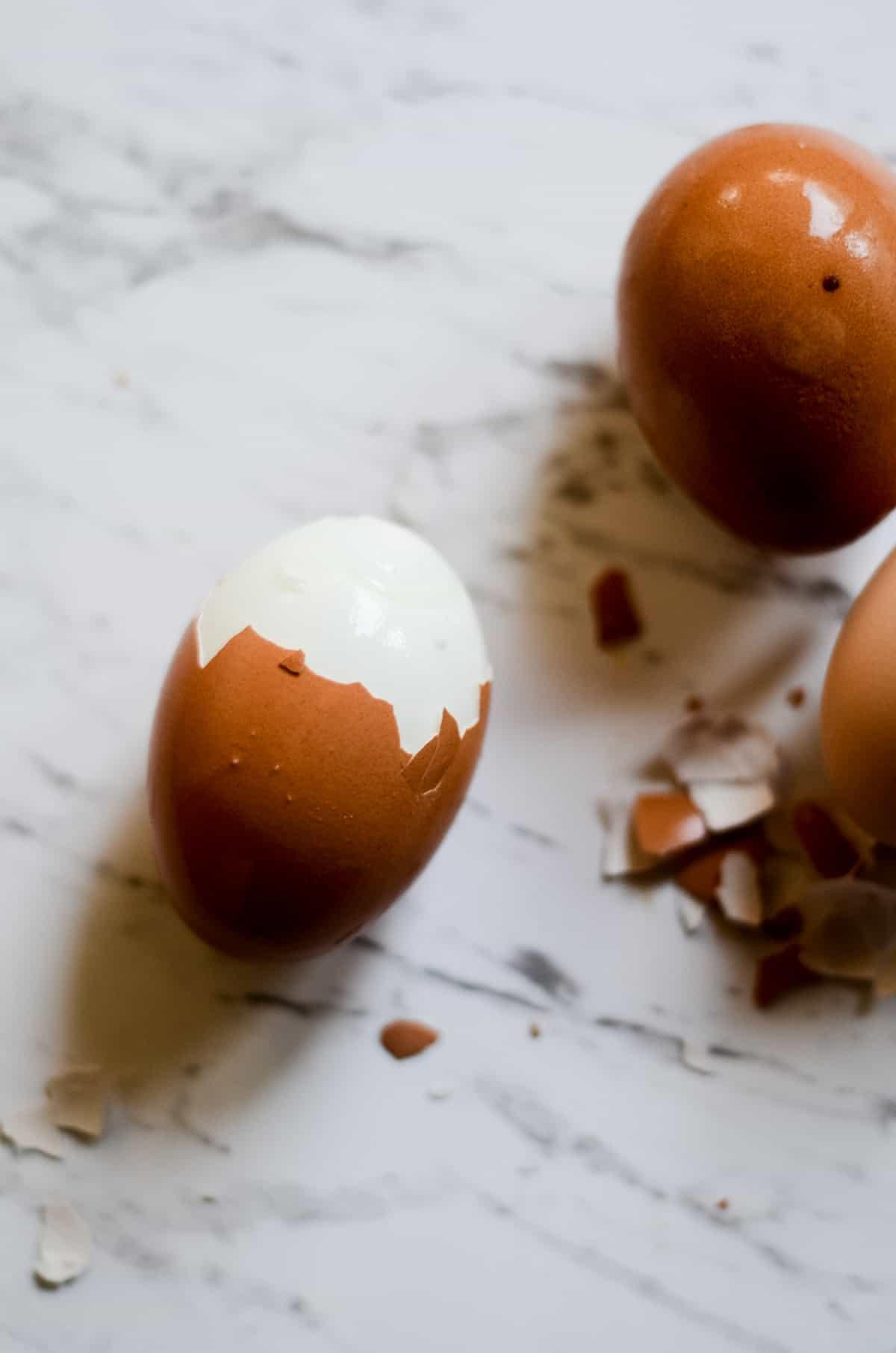 Close up shot of a single, perfectly peeled boiled egg dusted with cocoa powder