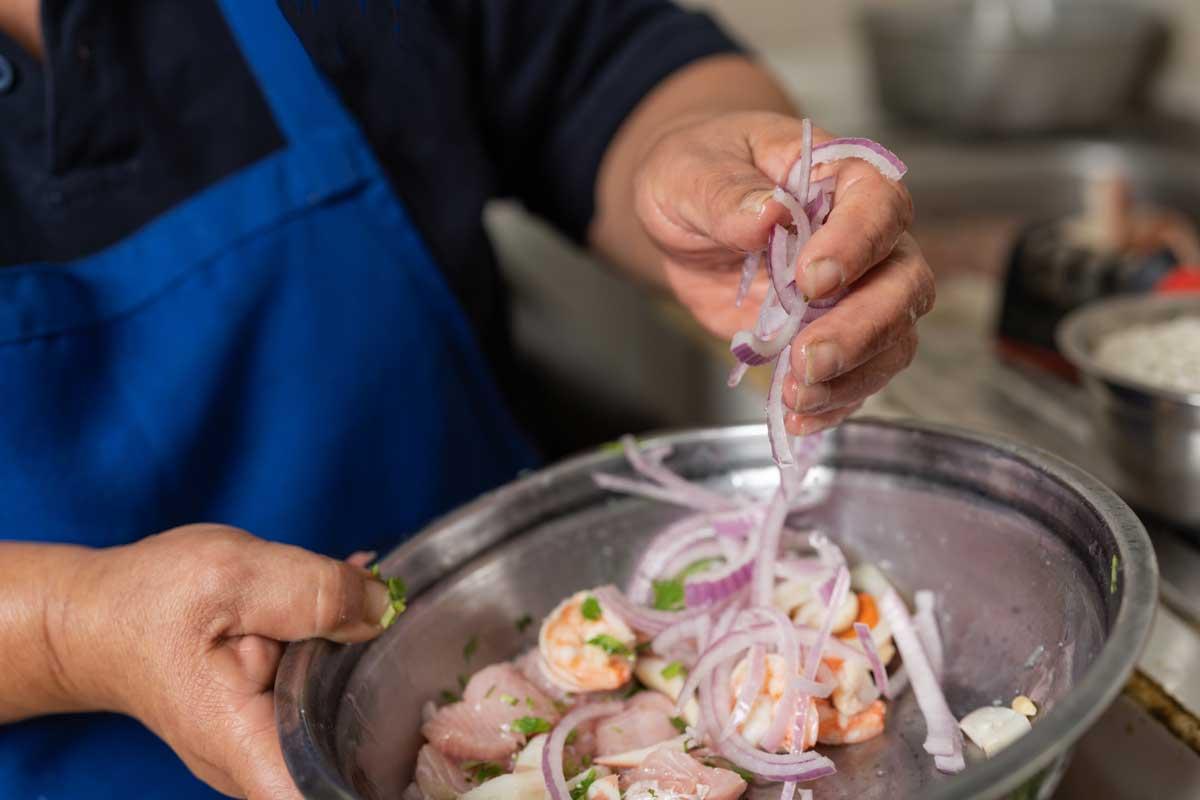 Person preparing ceviche, showcasing the different ingredients