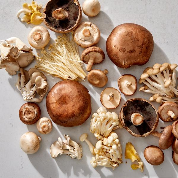 A vibrant image showcasing various types of mushrooms, like shiitake, oyster, and cremini, freshly chopped and ready to be used.