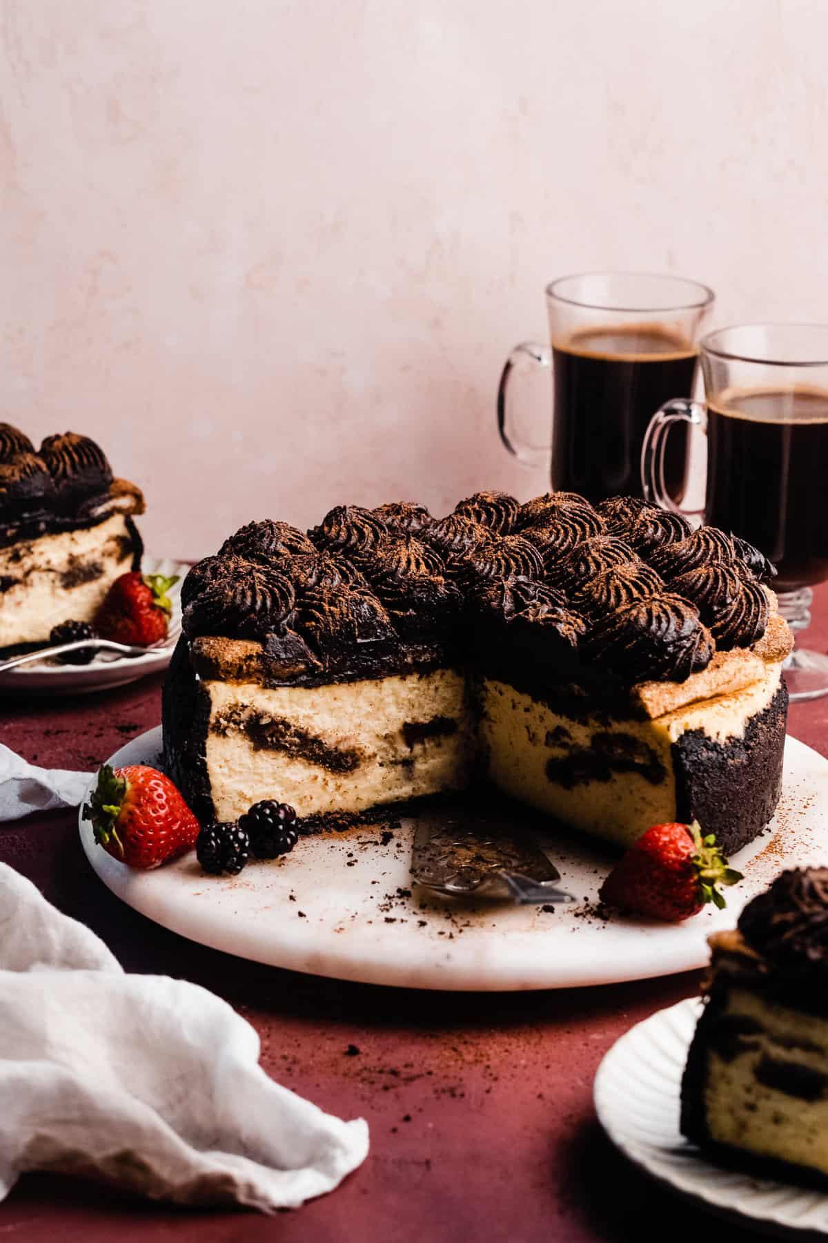 A beautifully styled image of the Tiramisu Cheesecake with Coffee Crumble, possibly with a steaming cup of coffee nearby