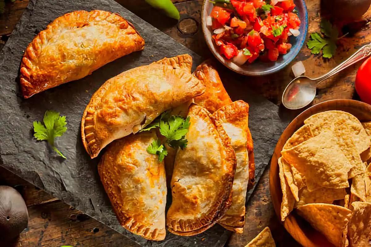 golden brown steamed saffron empanadas on a baking sheet