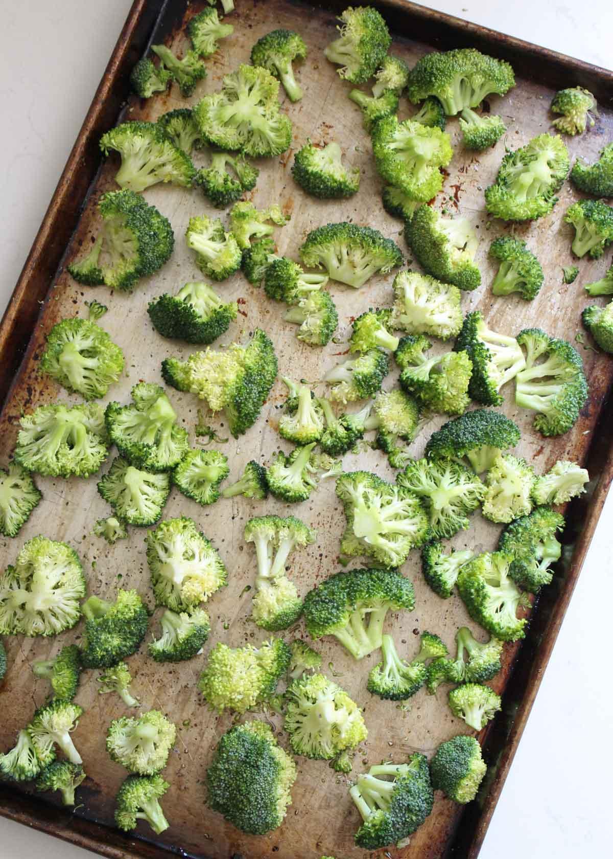 pan of roasted broccoli being taken out of the oven