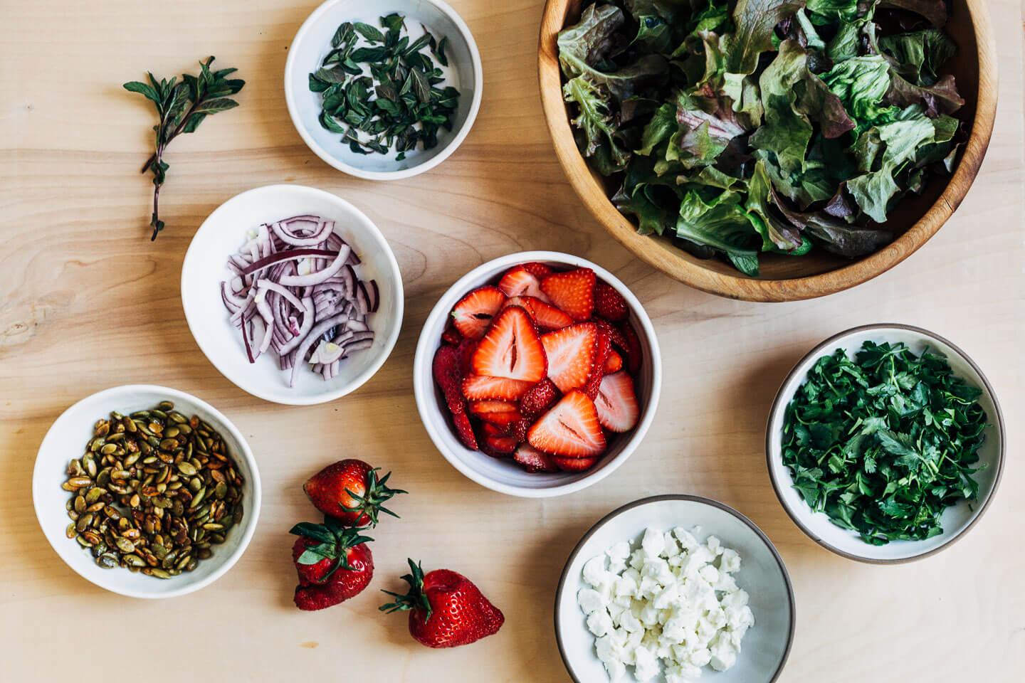 fresh chervil and strawberries being prepared for salad