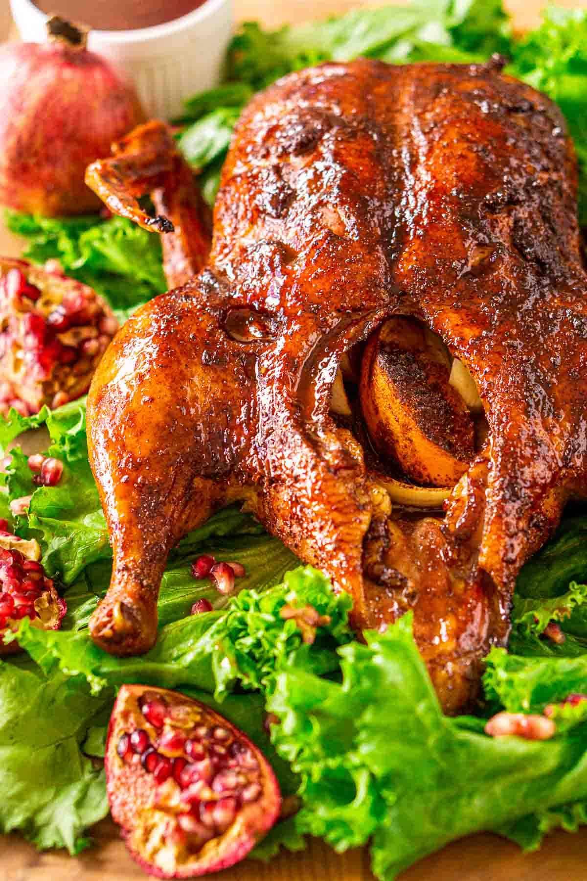 a person cutting into a perfectly roasted pomegranate glazed duck leg