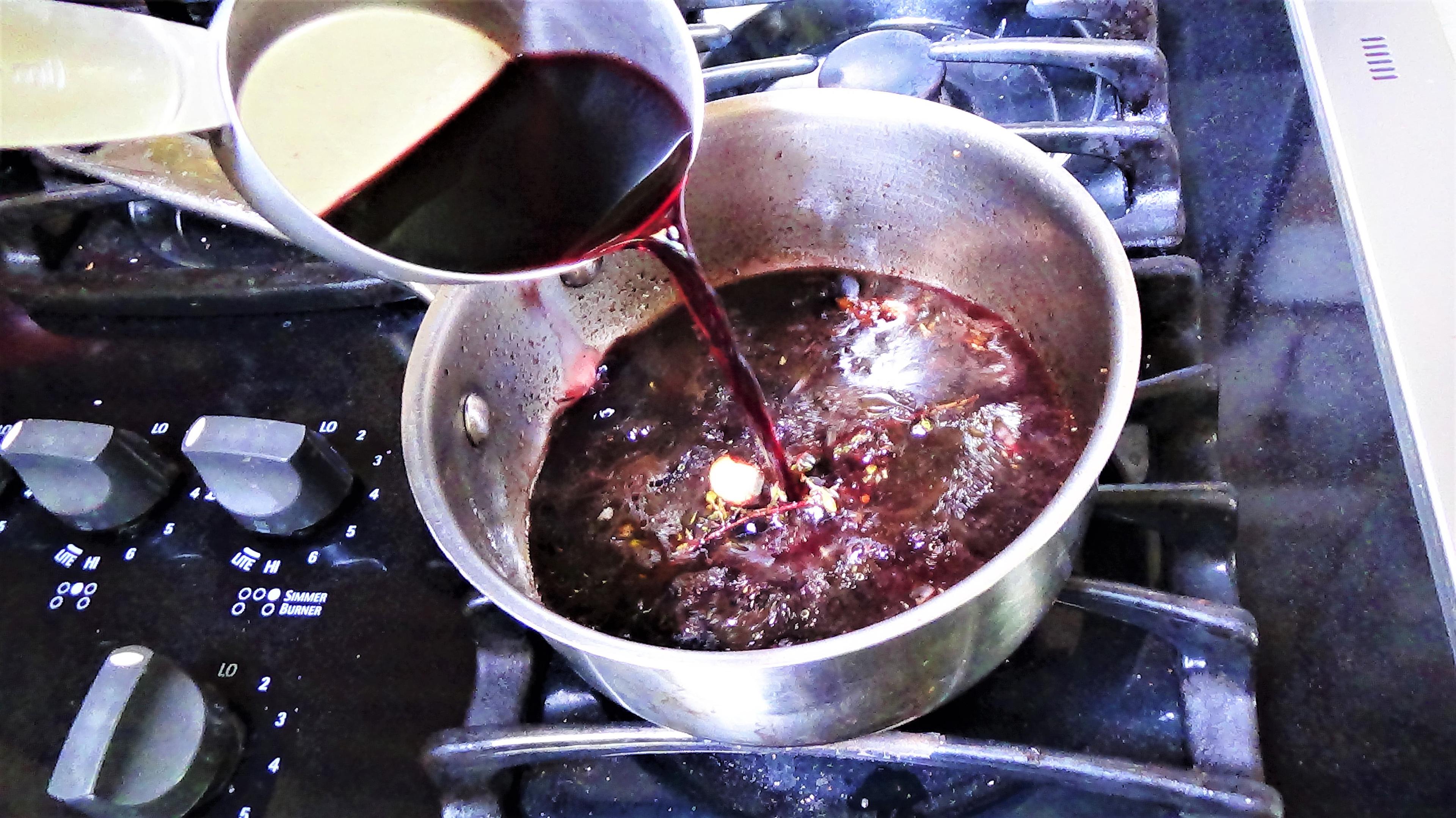 The red wine reduction simmering in a saucepan