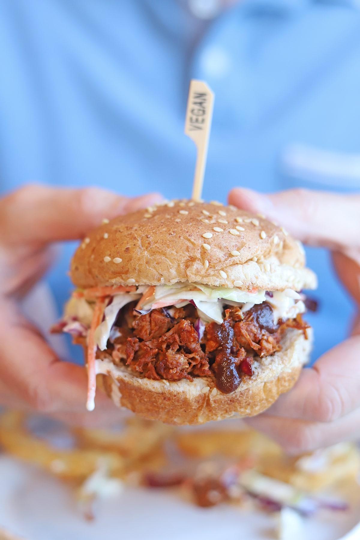 A person taking a bite of a BBQ jackfruit arepa
