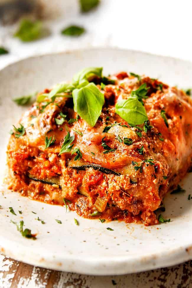 A delicious-looking zucchini lasagna with a sweet and sour sauce, garnished with fresh basil