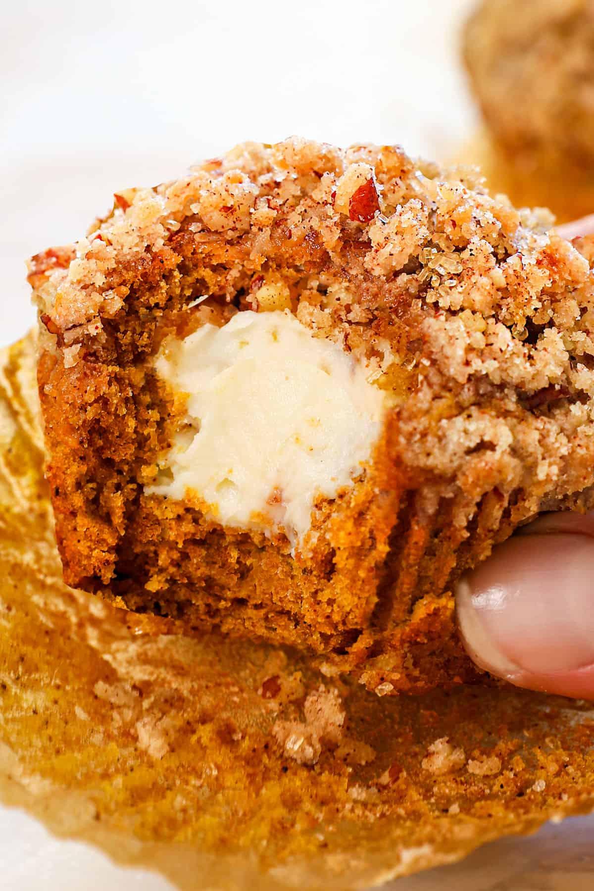 pumpkin cream cheese muffin with a bite taken out of it, showing the texture