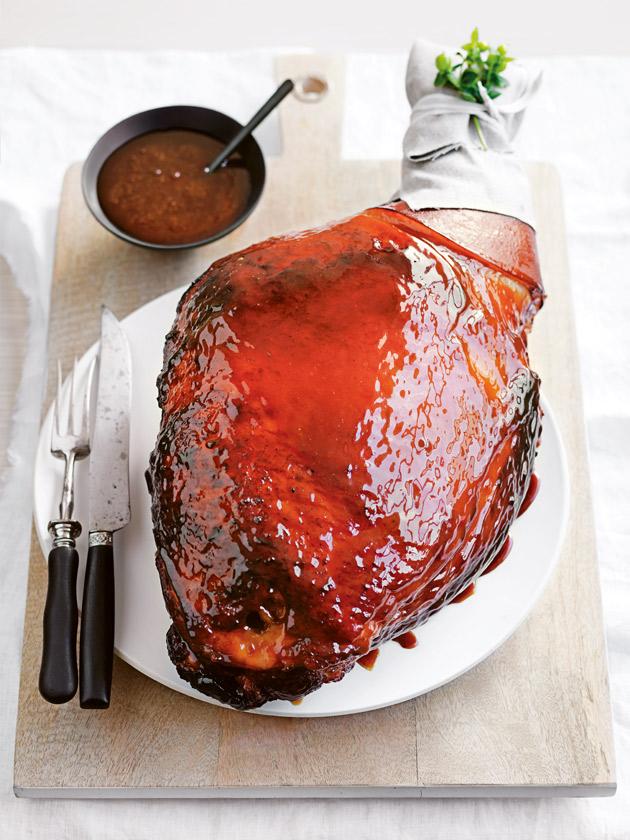 overhead shot of a beautifully glazed apple-sage brined ham on a festive christmas table