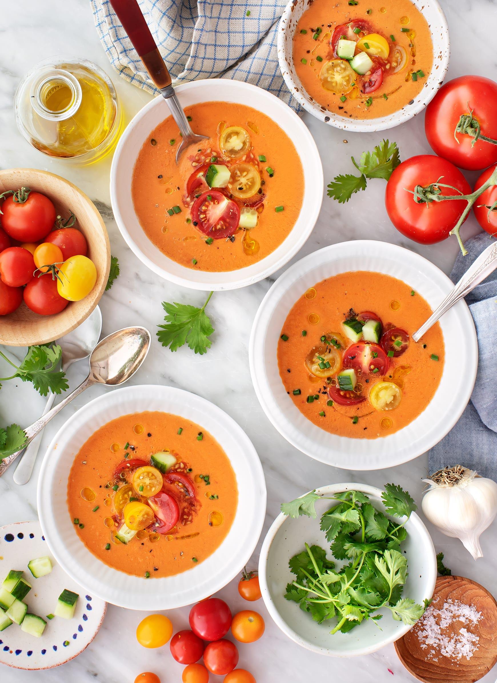 A vibrant bowl of gazpacho with rice, garnished with fresh herbs and a drizzle of olive oil
