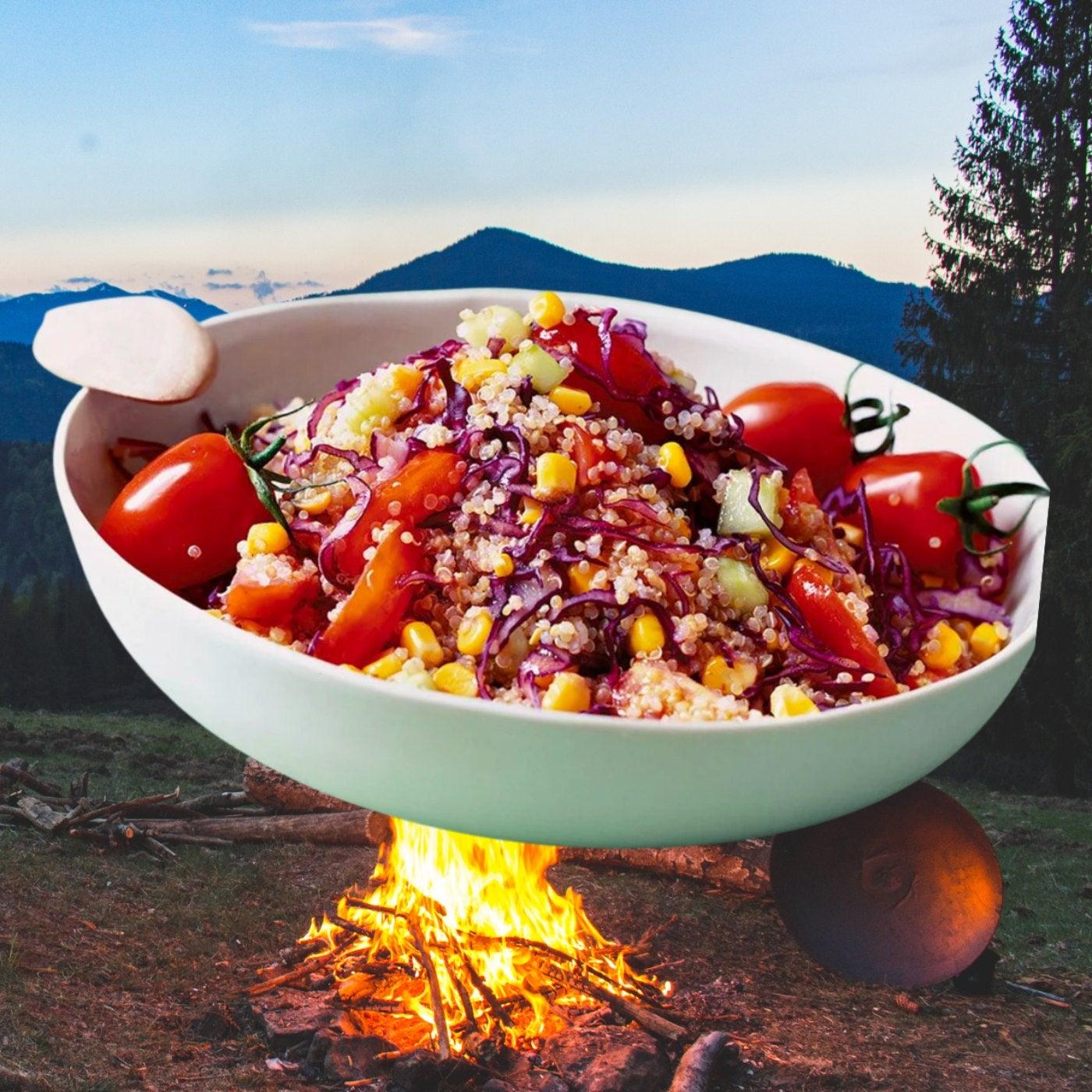 A person enjoying a bowl of quinoa salad outdoors