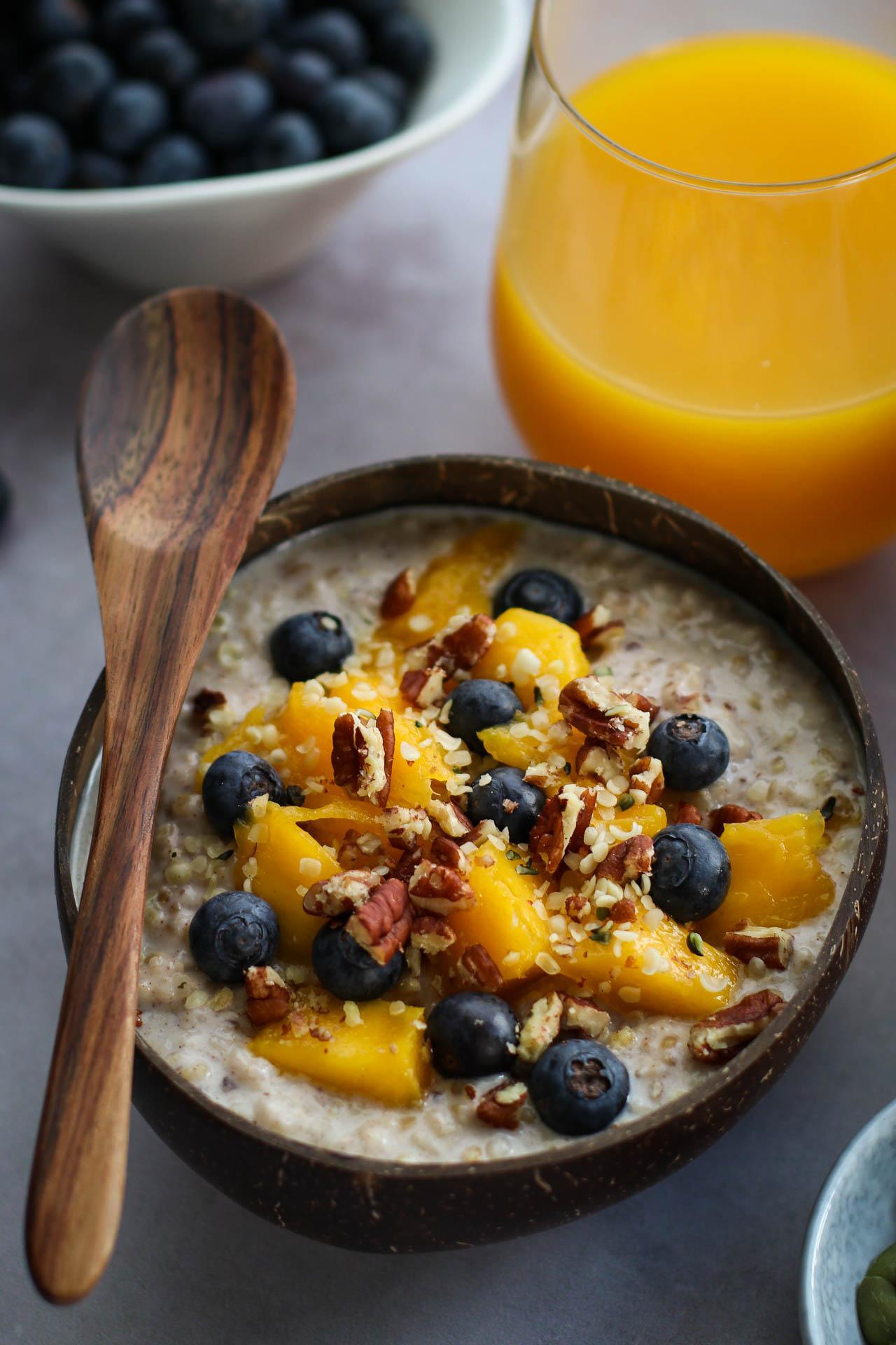 A warm and inviting bowl of lentil oatmeal with coconut milk, topped with fresh fruit and nuts