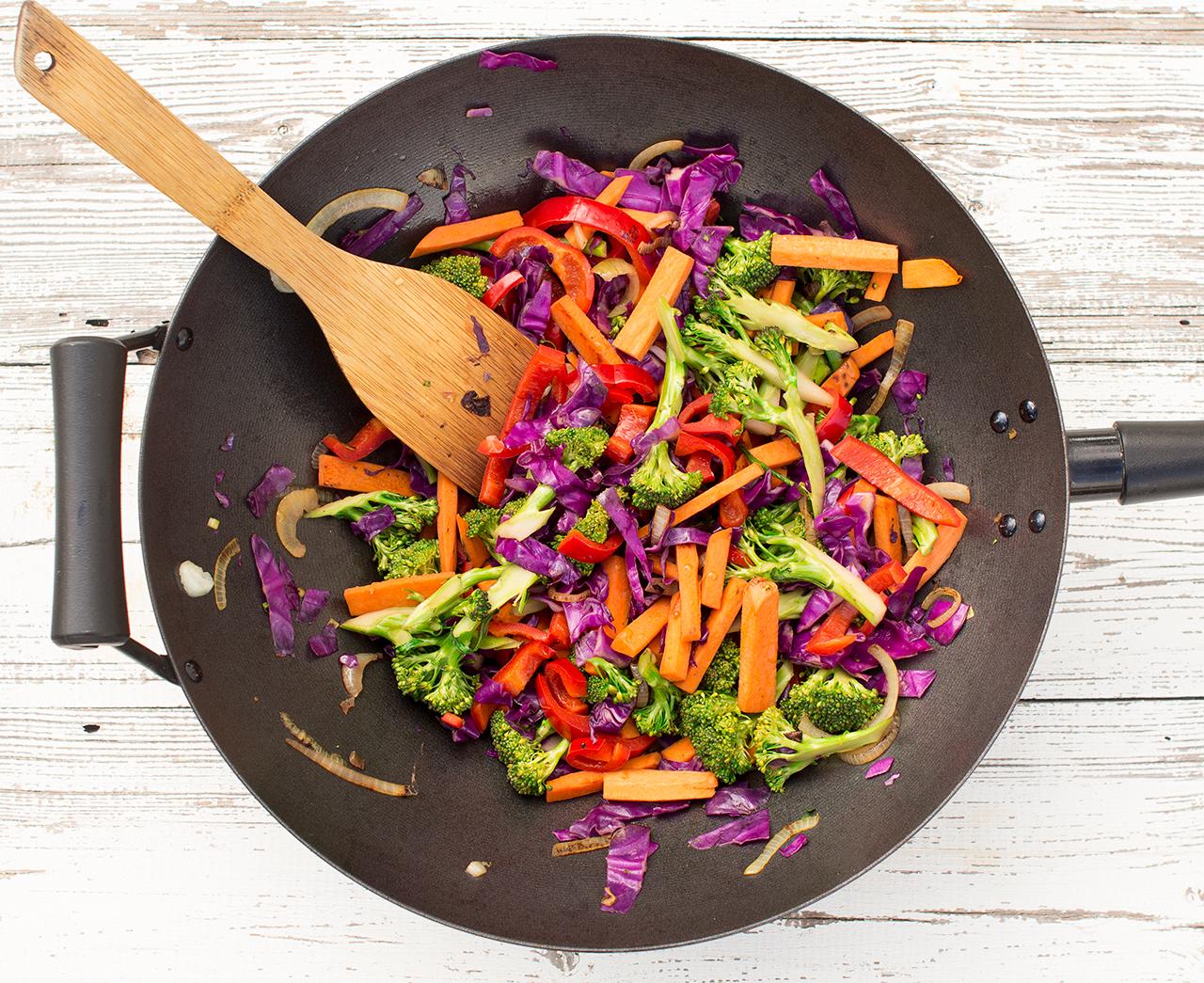 overhead shot of spicy peanut stir-fry with colorful vegetables and peanuts