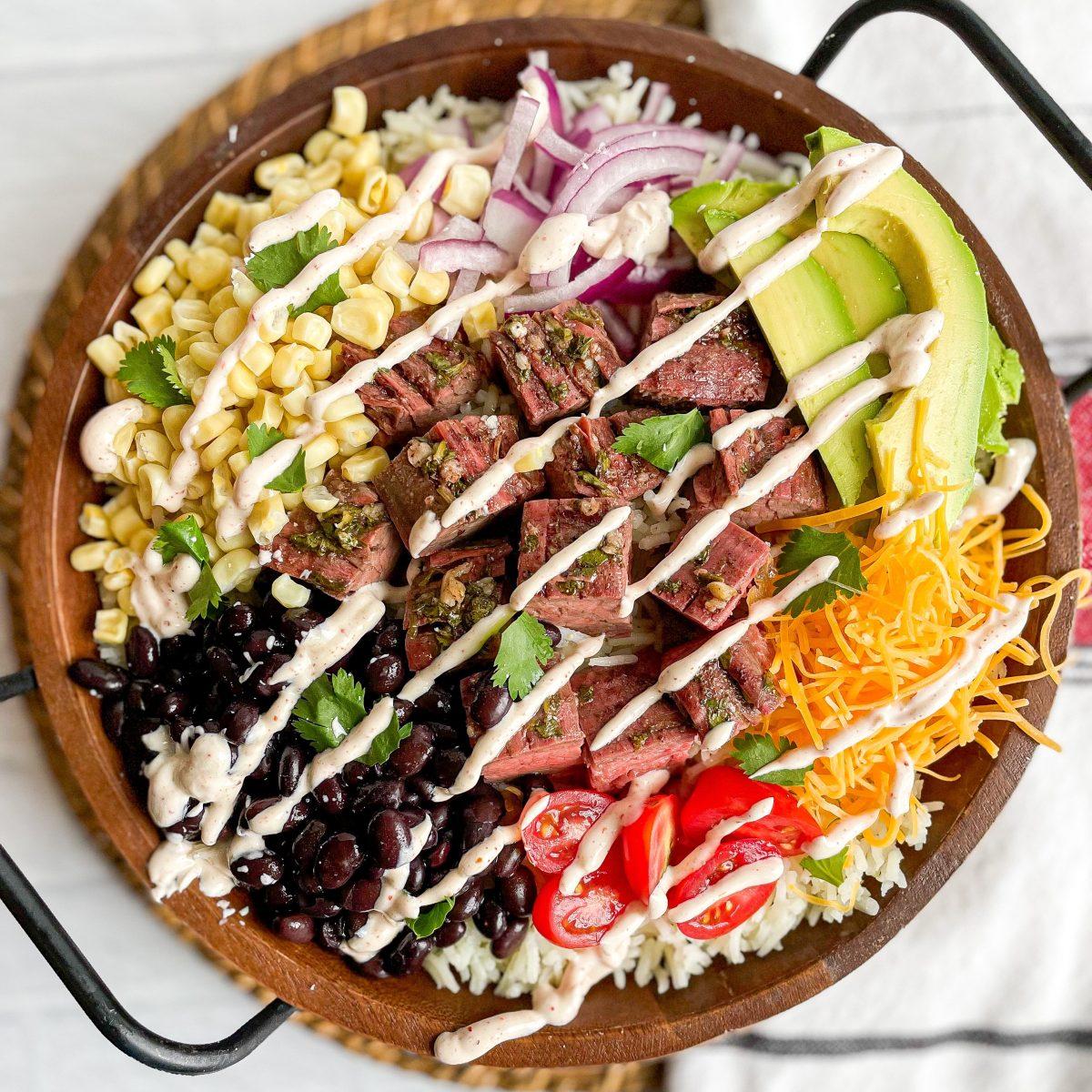 raw skirt steak marinating in a bowl with cilantro-lime dressing