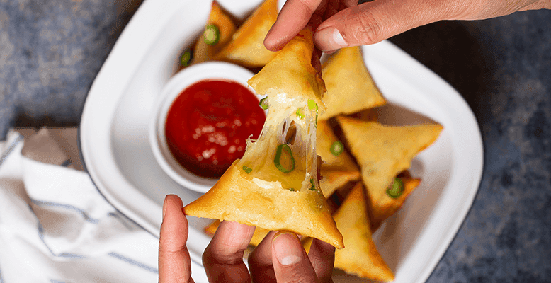 cut open chili cheese fries samosa with chili, cheese, fries and samosa visible