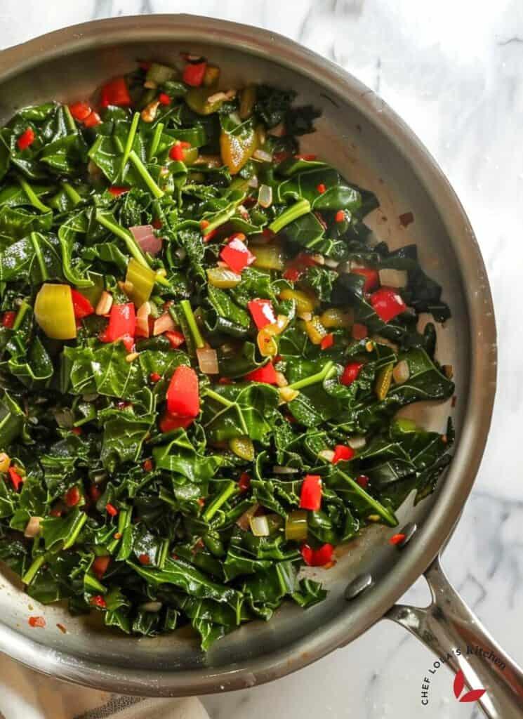 Close-up shot of callaloo ingredients: callaloo leaves, onions, garlic, scotch bonnet pepper, coconut milk