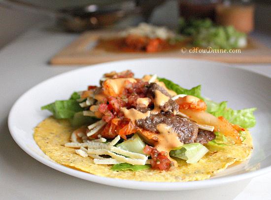 A person enthusiastically taking a bite of a kimchi and black rice taco